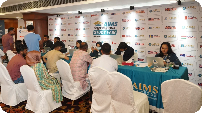 Counselors seated at a study abroad event, offering guidance and support to students